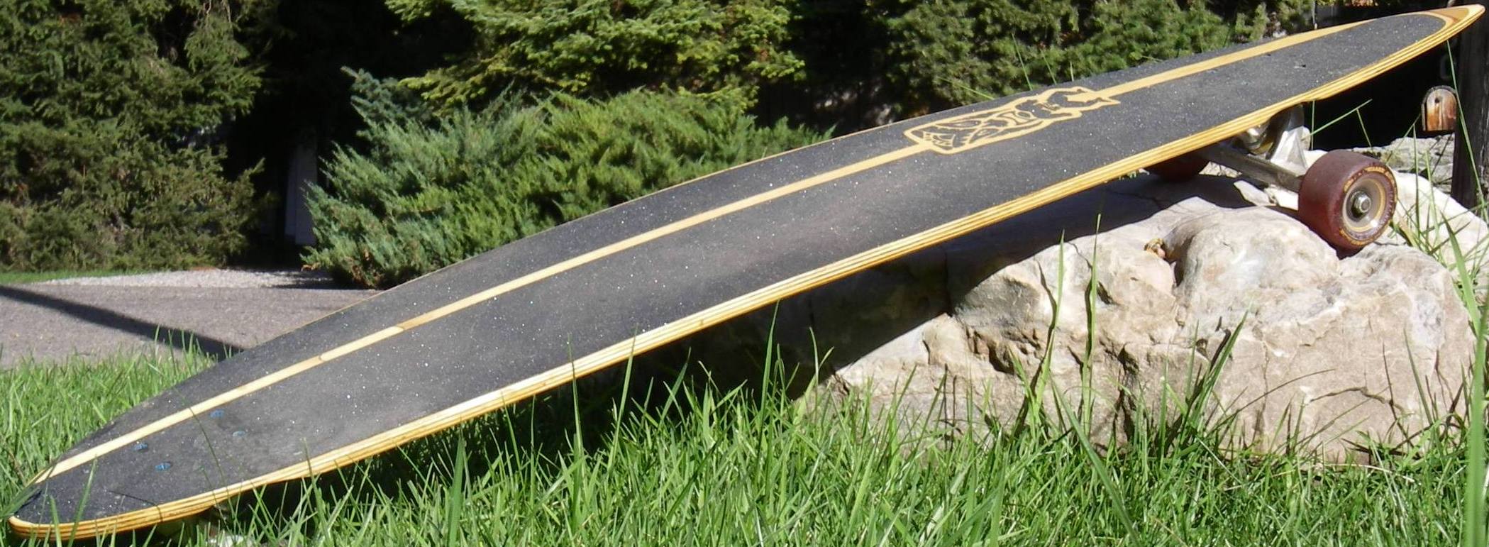 Board with Tiki using a rock as a kickstand.